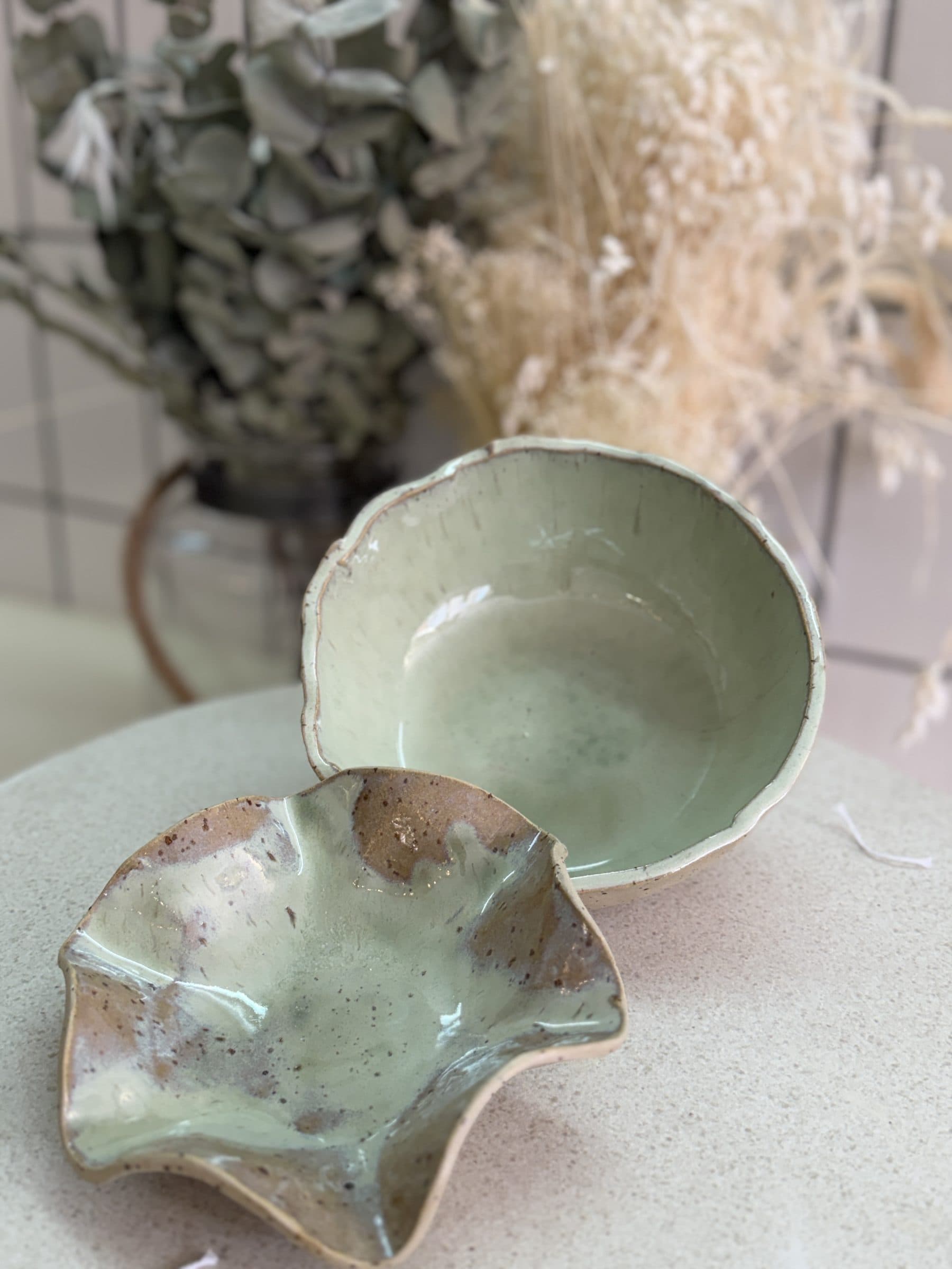 Grün glasierte Keramikschalen mit Trockenblumen
