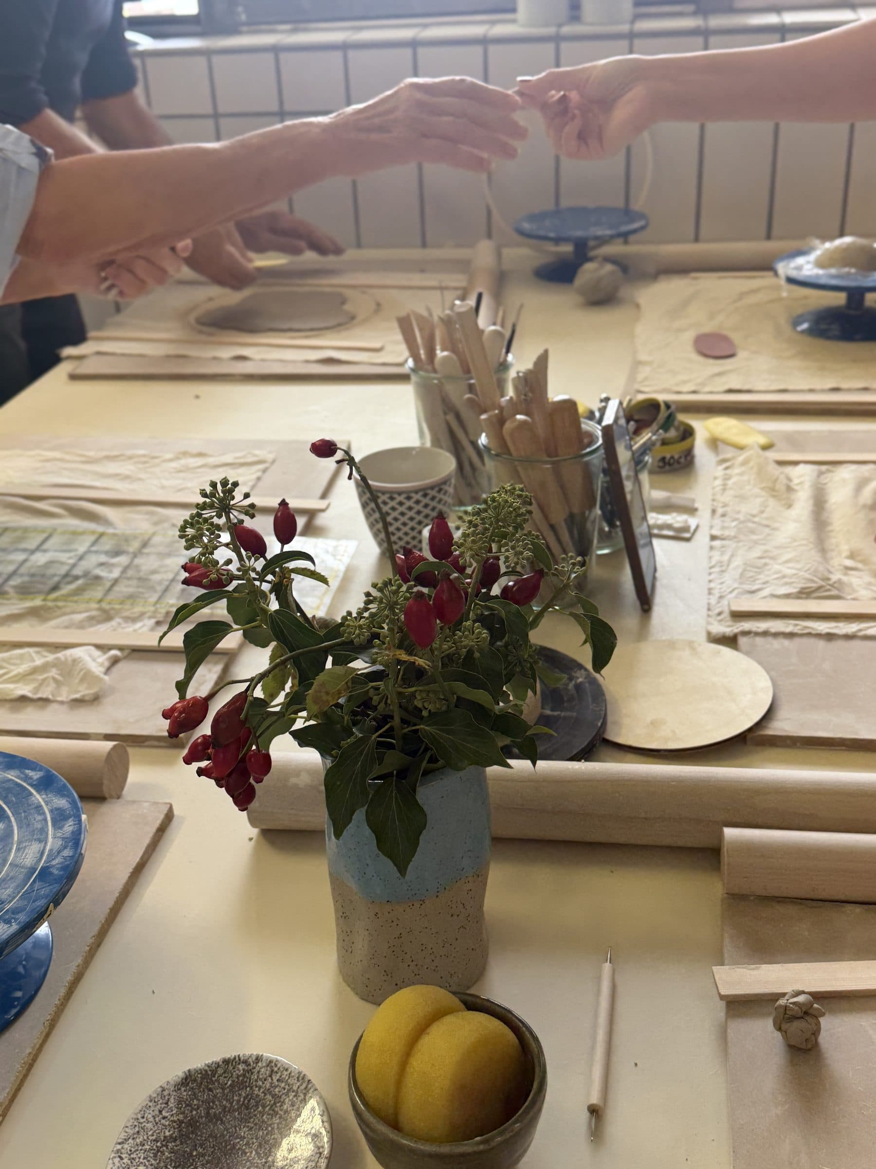 Gemeinsames Arbeiten am Werktisch mit Blumen und Werkzeug